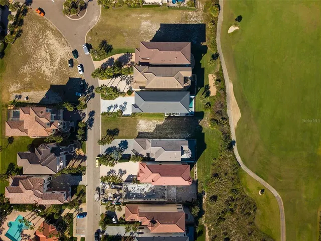 an aerial view of a house with swimming pool a yard and lake view