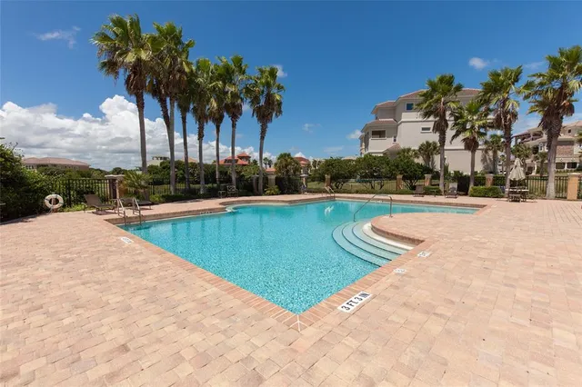 a view of a swimming pool with a table and chairs under an umbrella