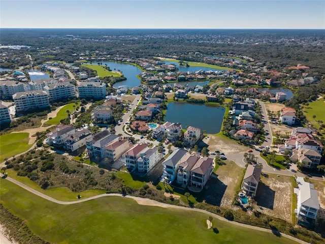 an aerial view of residential houses with outdoor space and parking
