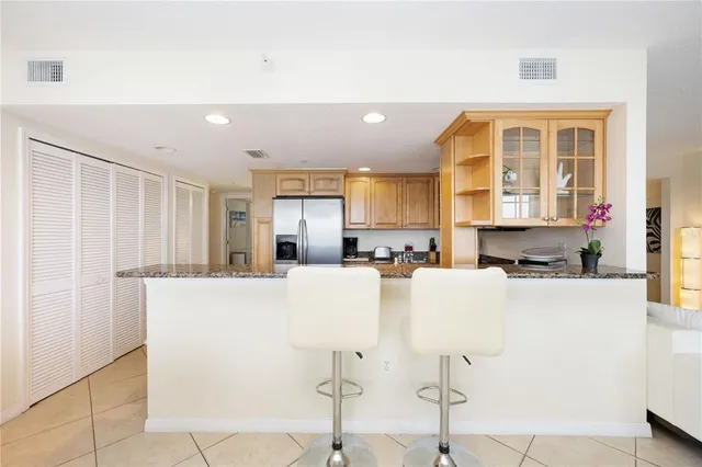 a kitchen with stainless steel appliances a refrigerator a stove a sink dishwasher and a refrigerator with wooden floor