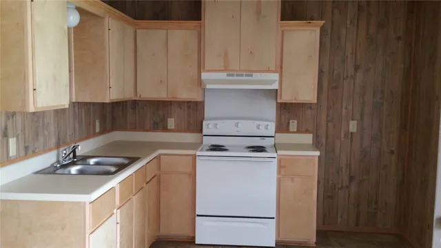 a kitchen with a sink stove and cabinets
