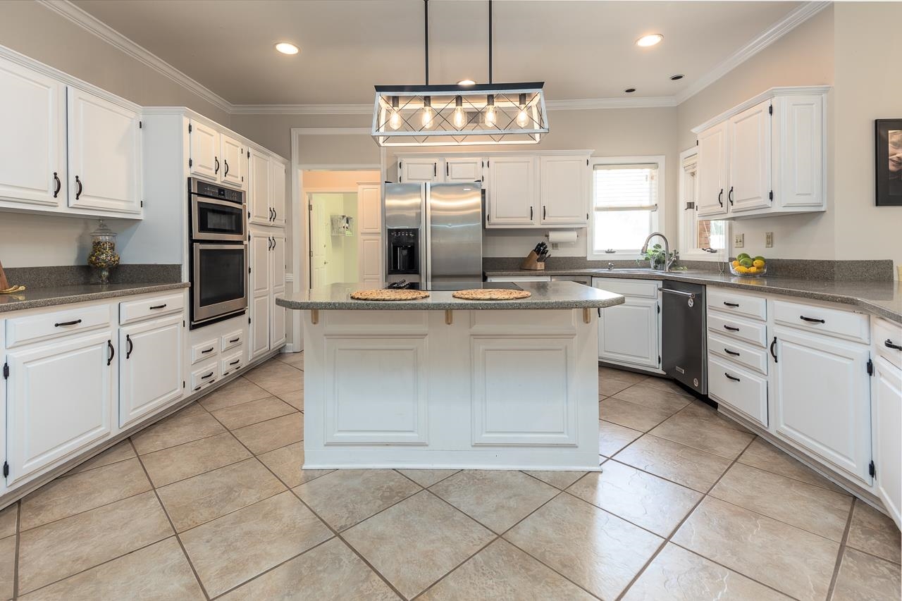 9637 Spring Meade Lane Germantown, TN 38139 - Photo 6 of 25 a kitchen with stainless steel appliances granite countertop a stove top oven a sink a counter top space cabinets and appliances