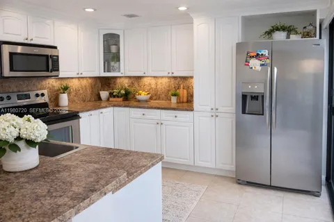 a kitchen with stainless steel appliances granite countertop a refrigerator a stove a microwave and a sink