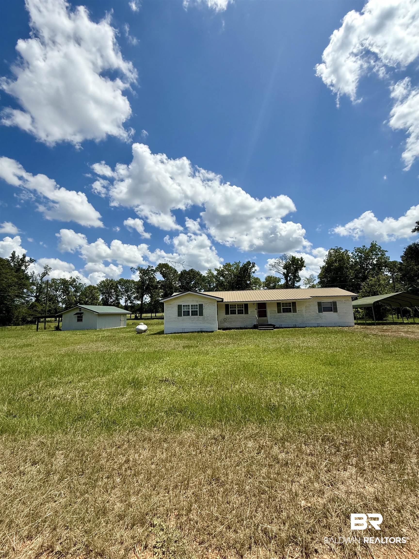 View of front of property featuring a detached carport and a front lawn