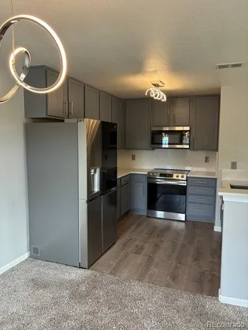 a kitchen with kitchen island stainless steel appliances a sink stove and refrigerator