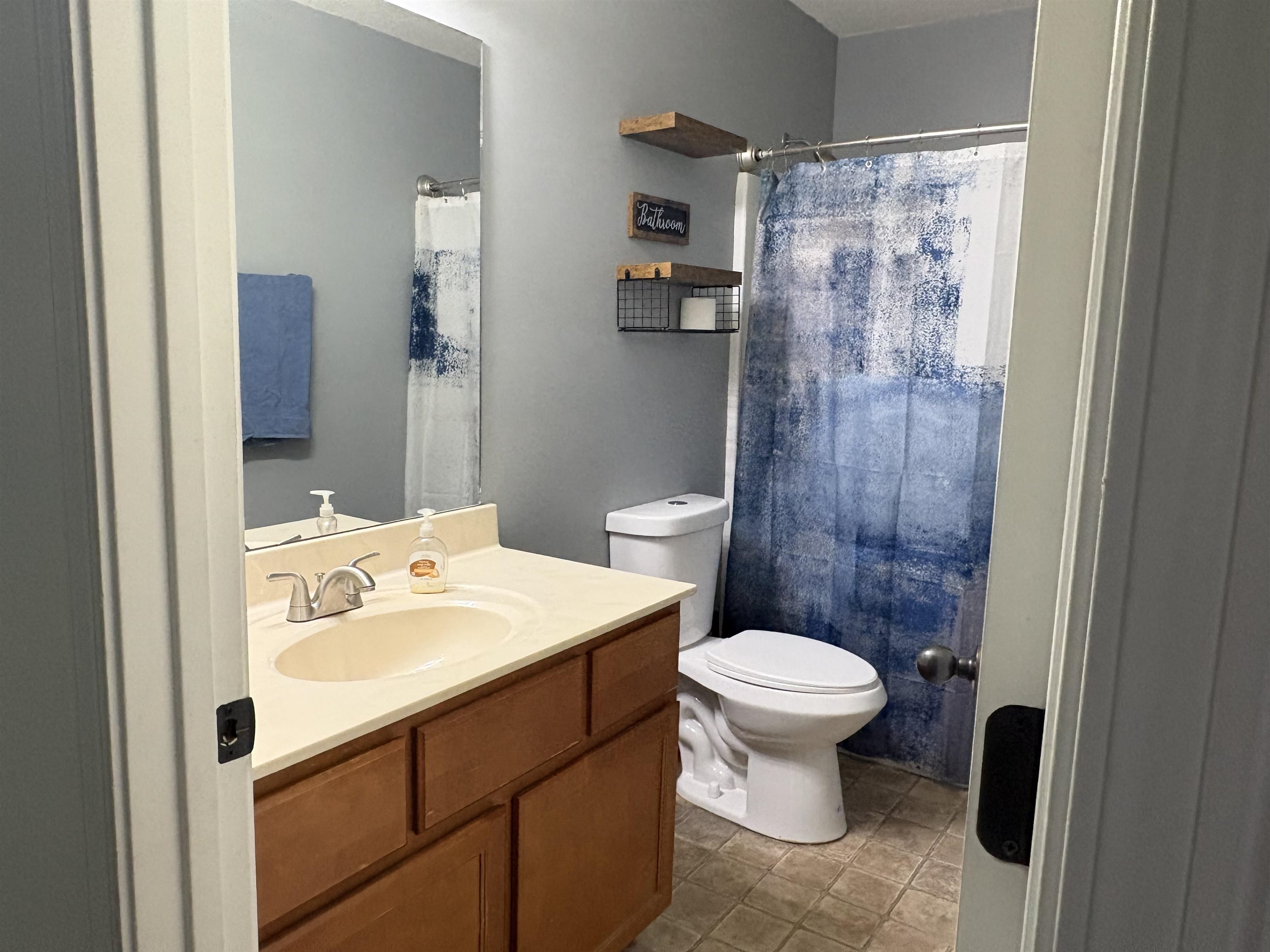 4356 Cedar Hills Road Memphis, TN 38135 - Photo 22 of 29 Bathroom featuring a vanity with a cream-toned countertop and integrated sink, chrome faucet, wood-finish cabinetry, and a toilet