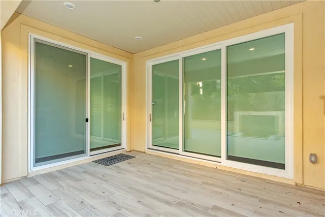 an empty room with wooden floor and sliding door