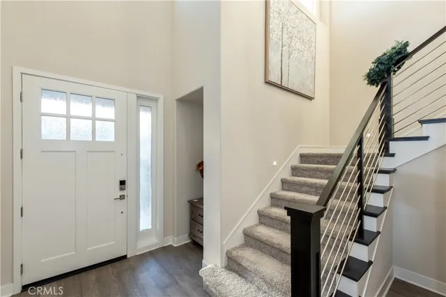 an entryway with a white walls and wooden floor