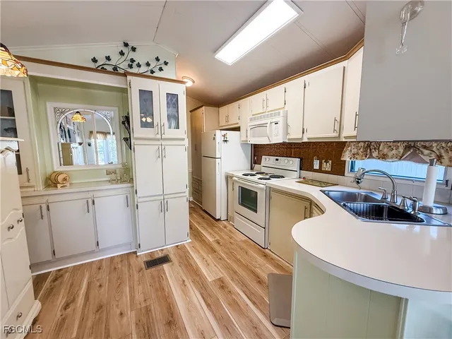 a kitchen with a sink appliances and cabinets