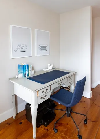 a living room with a table chairs and a wooden floor