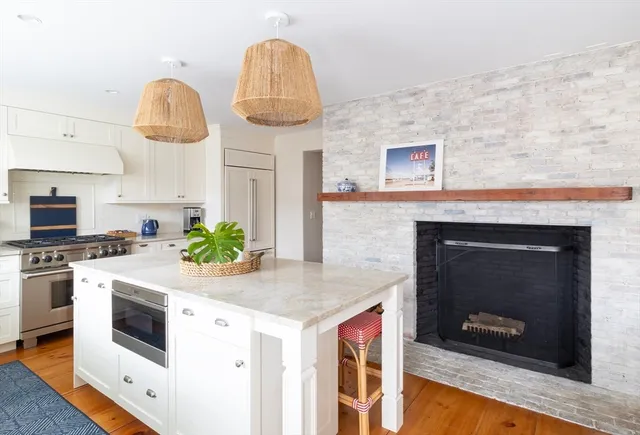 a kitchen with stainless steel appliances granite countertop a stove a microwave and a white cabinets