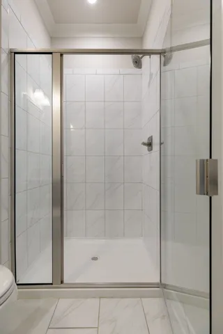 an empty room with wooden floor fireplace and windows