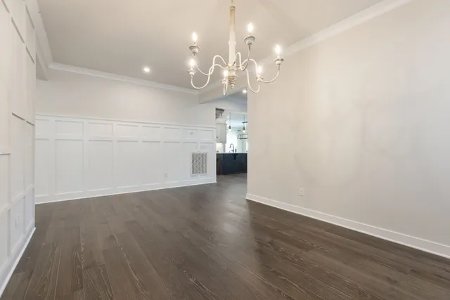 a view of a hallway with wooden floor and a ceiling fan