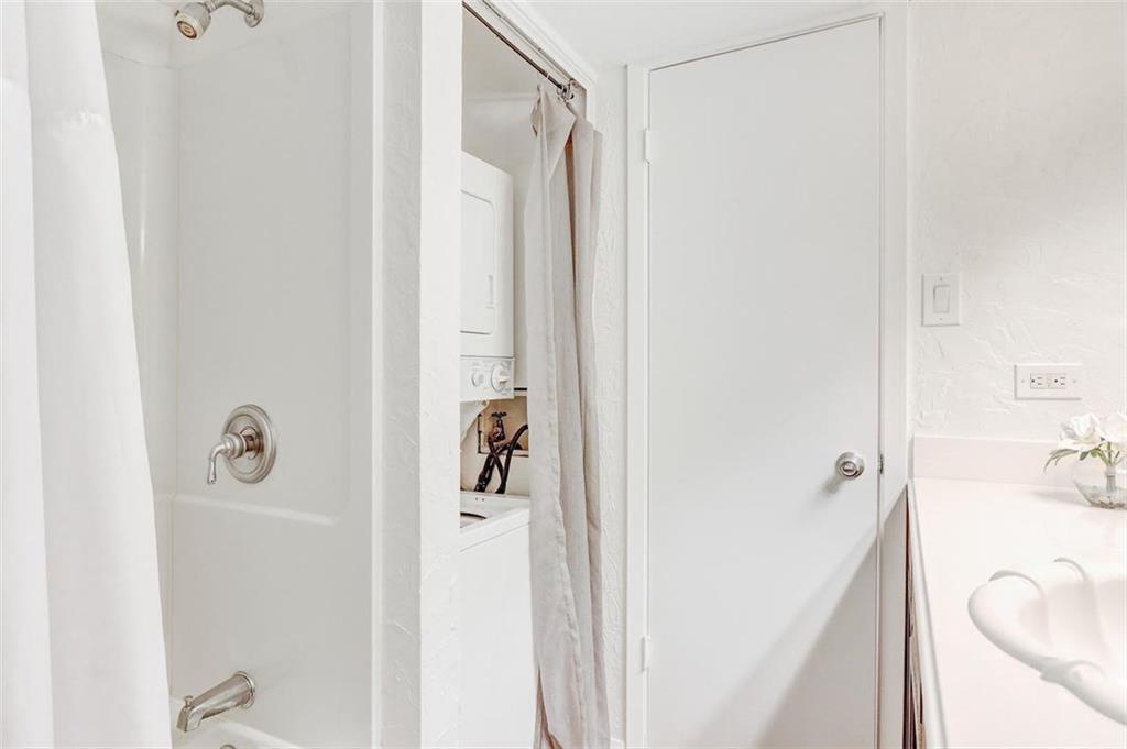 3115 Helms Street, Unit 204 Austin, TX 78705 - Photo 8 of 13 A pristine bathroom features a shower-over-tub combination and a conveniently integrated laundry area.