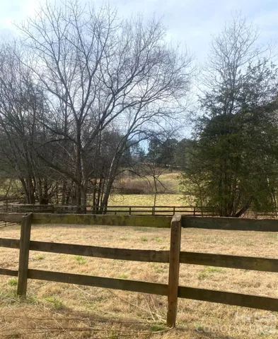 a view of a yard with wooden fence