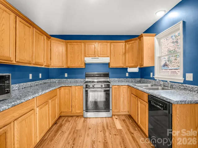 a kitchen with stainless steel appliances granite countertop a refrigerator and a stove top oven