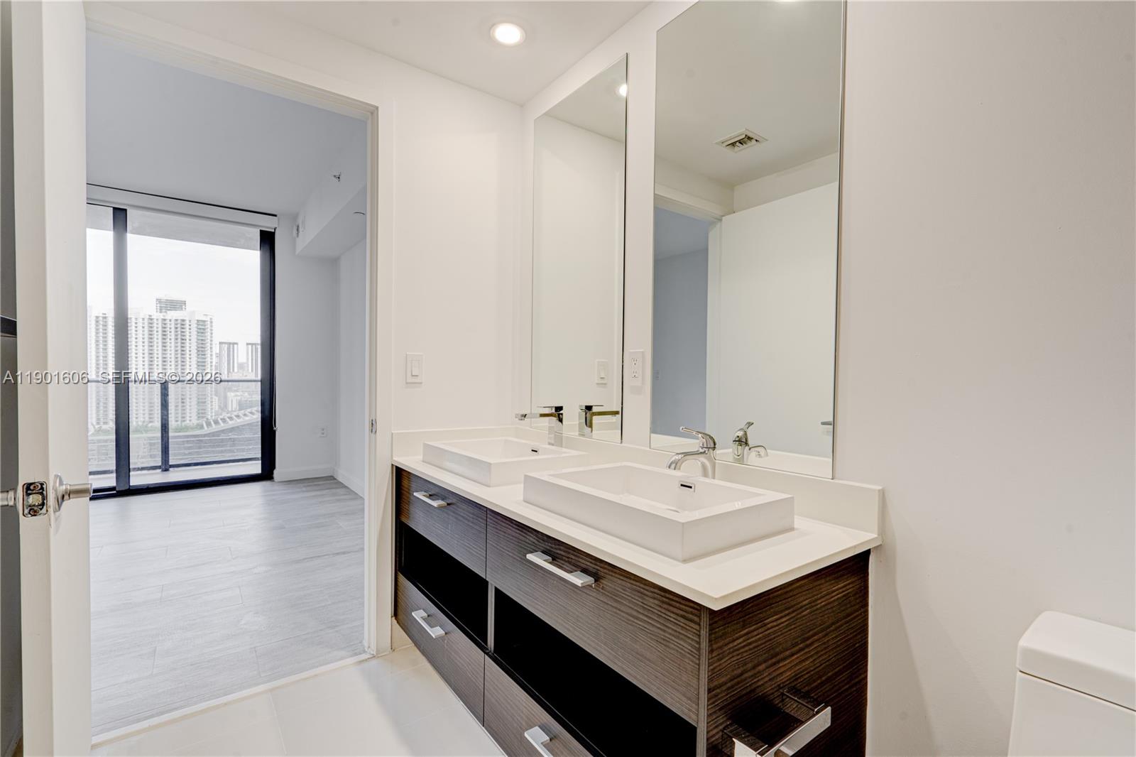 45 Southwest 9th Street, Unit 2408 Miami, FL 33130 - Photo 12 of 37 a bathroom with a sink and a mirror