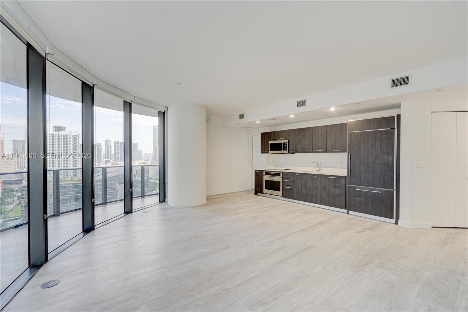 45 Southwest 9th Street, Unit 2408 Miami, FL 33130 - Photo 3 of 37 a view of an empty room with kitchen view and a window