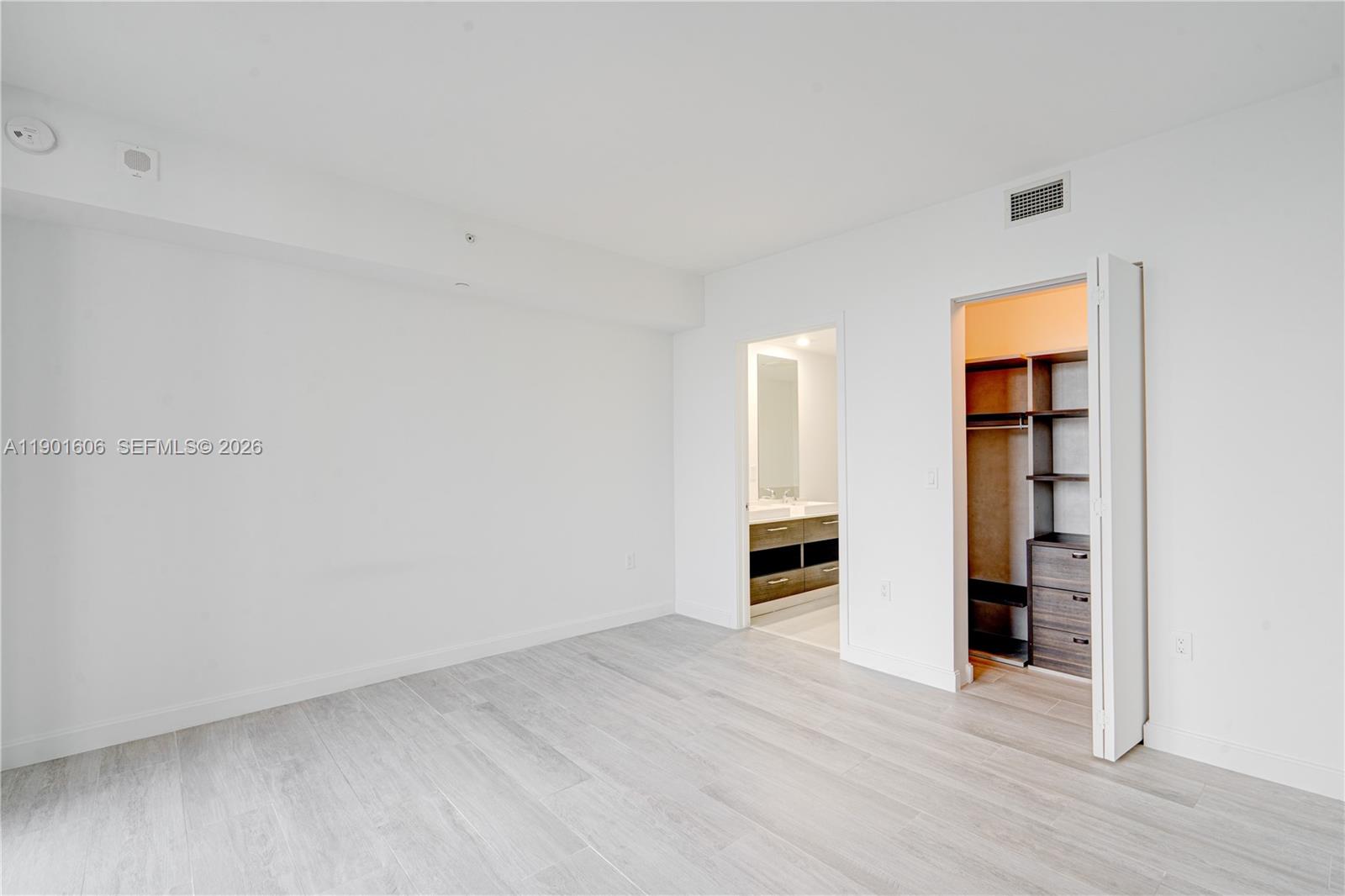 45 Southwest 9th Street, Unit 2408 Miami, FL 33130 - Photo 8 of 37 an empty room with closet and windows