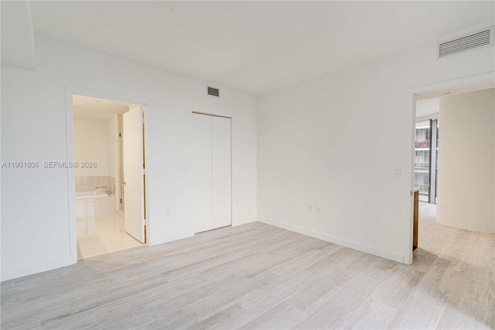 45 Southwest 9th Street, Unit 2408 Miami, FL 33130 - Photo 9 of 37 an empty room with wooden floor and windows