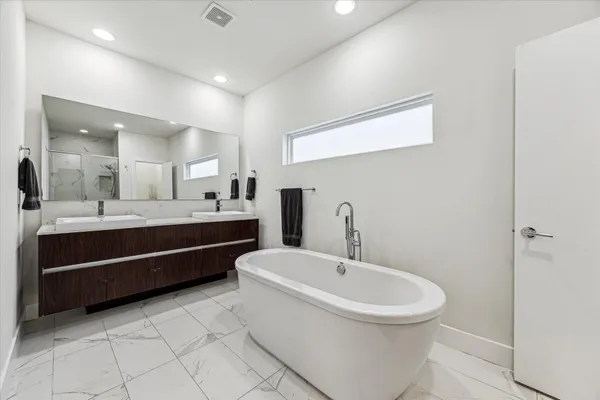a bathroom with a double vanity sink a mirror and a toilet