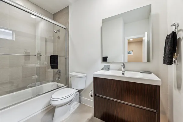 a bathroom with a toilet a sink and a large mirror