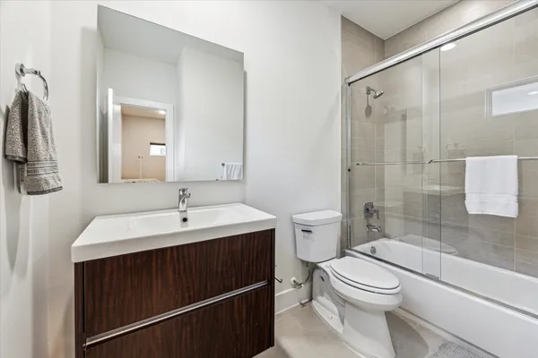 a bathroom with a sink toilet a mirror and shower