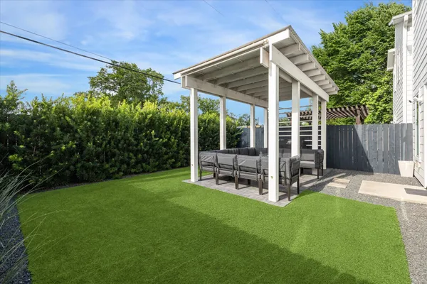a view of a chair and table in backyard of the house