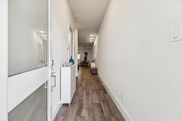 a view of a hallway with wooden floor and staircase