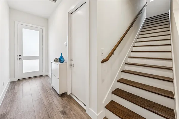 a view of a hallway with wooden floor and entryway