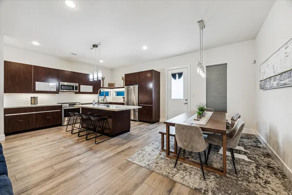 a living room with stainless steel appliances kitchen island granite countertop furniture wooden floor and a view of kitchen