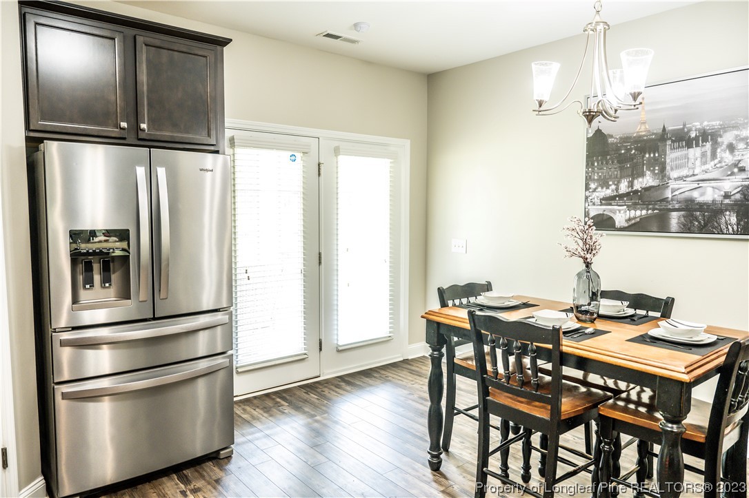96 Eaker Drive Cameron, NC 28326 - Photo 13 of 41 a kitchen with stainless steel appliances granite countertop a refrigerator a stove and a dining table with wooden floor
