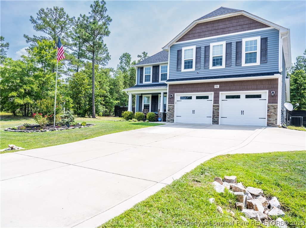 96 Eaker Drive Cameron, NC 28326 - Photo 2 of 41 a front view of a house with a yard and garage