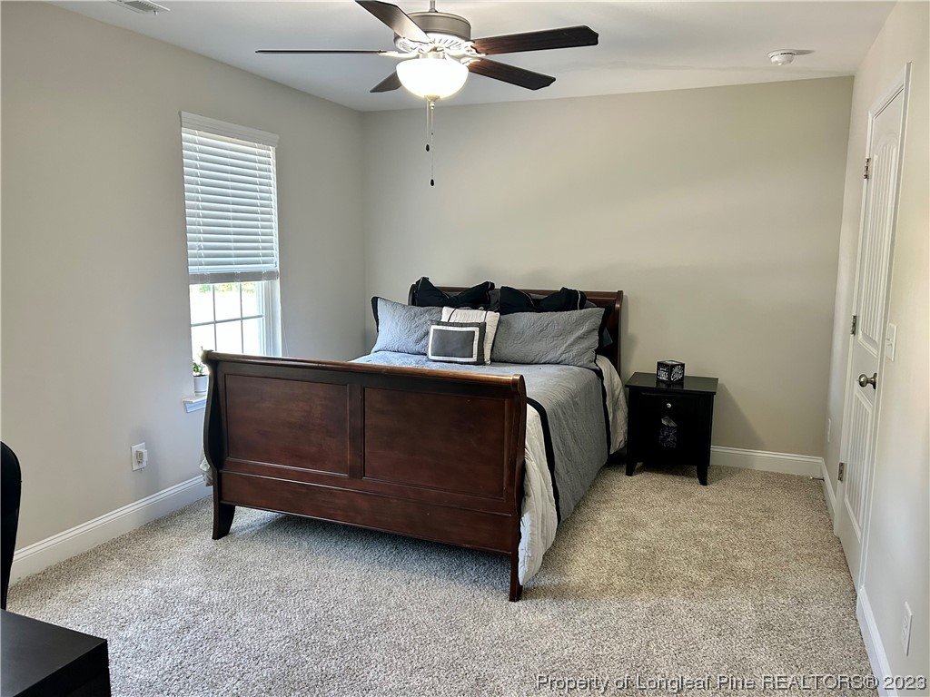96 Eaker Drive Cameron, NC 28326 - Photo 29 of 41 a bedroom with a bed and a chandelier