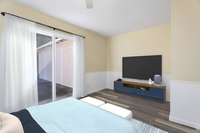 a bedroom with a bed and a flat screen tv