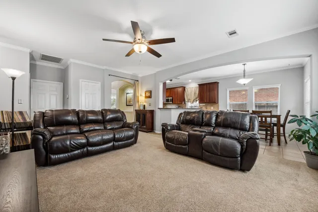 a living room with furniture and a ceiling fan