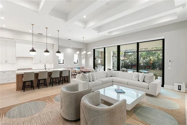 a large living room with lots of white furniture and a large window