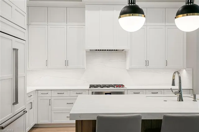 a kitchen with a stove a table and chairs in it