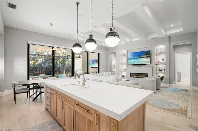 a kitchen with kitchen island granite countertop a sink cabinets a refrigerator and a stove