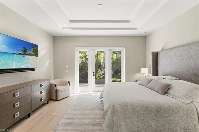 a bedroom with a bed a table and a large window