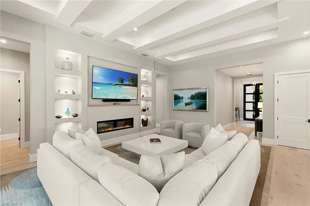 a dining room with wooden floor a chandelier a wooden table and chairs