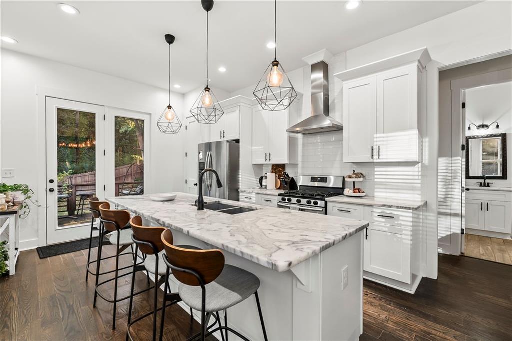 1771 Derry Avenue Southwest Atlanta, GA 30310 - Photo 16 of 45 a view of a kitchen with granite countertop a stove a sink a dining table and chairs