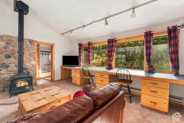 1701 Oak Road Coalville, UT 84017 - Photo 56 of 71 Vaulted ceiling, stone accent wall, wood-burning stove, track lighting, and built-in desk cabinetry