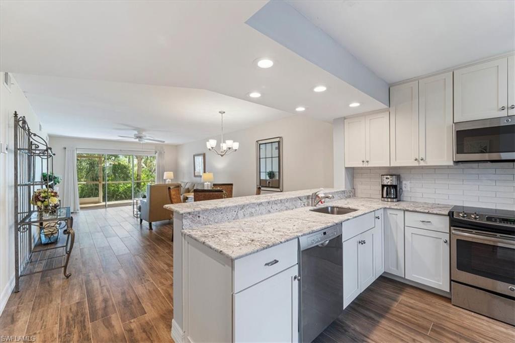 3012 Sandpiper Bay Circle, Unit D101 Naples, FL 34112 - Photo 27 of 27 a kitchen with a sink stove and wooden cabinets
