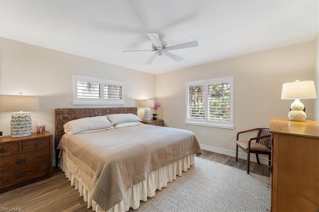 3012 Sandpiper Bay Circle, Unit D101 Naples, FL 34112 - Photo 10 of 27 a bedroom with a bed a desk and chair with window