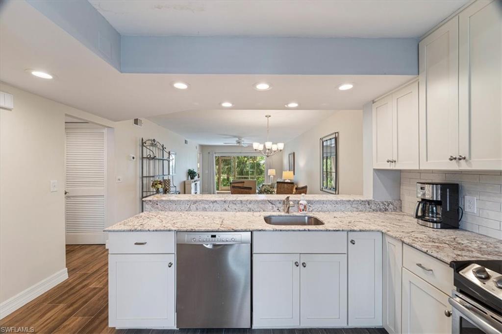 3012 Sandpiper Bay Circle, Unit D101 Naples, FL 34112 - Photo 3 of 27 a kitchen with granite countertop white cabinets and white appliances
