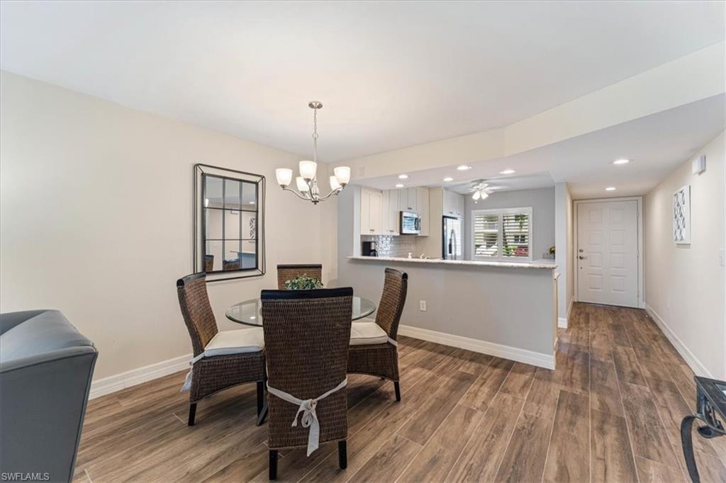 3012 Sandpiper Bay Circle, Unit D101 Naples, FL 34112 - Photo 6 of 27 a view of a dining room with furniture and wooden floor