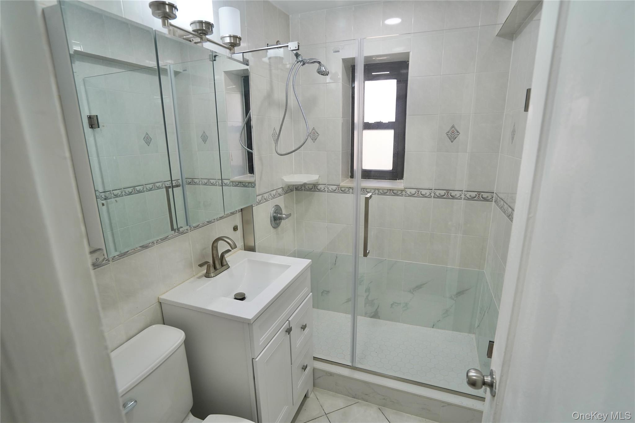 102-55 67th Road, Unit 3W Queens, NY 11375 - Photo 6 of 12 a bathroom with a shower sink mirror and toilet