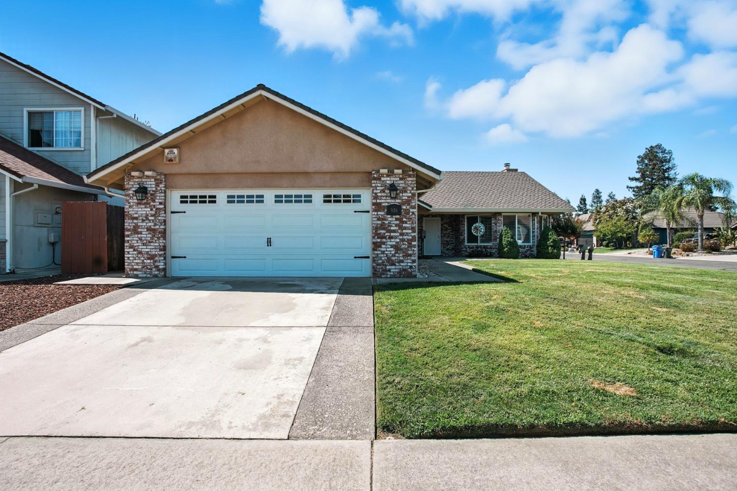 906 Ranch Road Galt, CA 95632 - Photo 2 of 38 view of front of home featuring driveway, an attached garage, a front yard, and brick siding