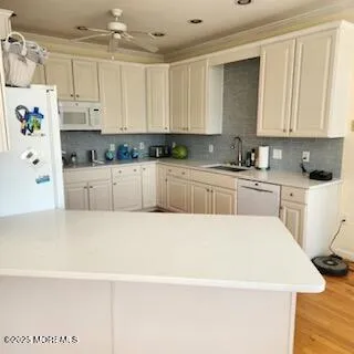 a white kitchen with a sink a stove and white cabinets
